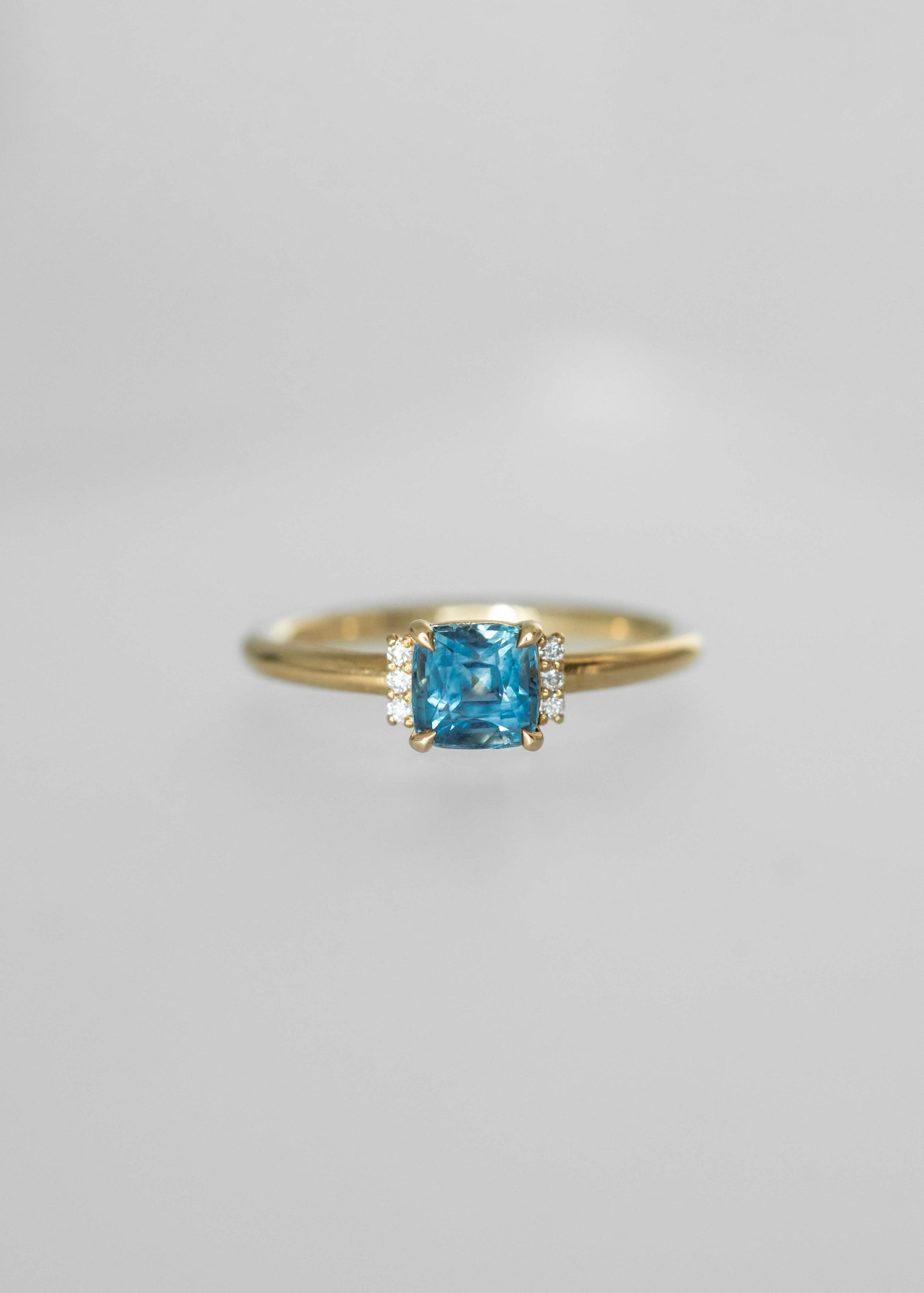 blue sapphire engagement ring, cushion cut sapphire ring, 18k yellow gold sapphire ring, modern solitaire ring, diamond accent engagement ring, ethical gemstone ring, colorful engagement ring, unique engagement rings