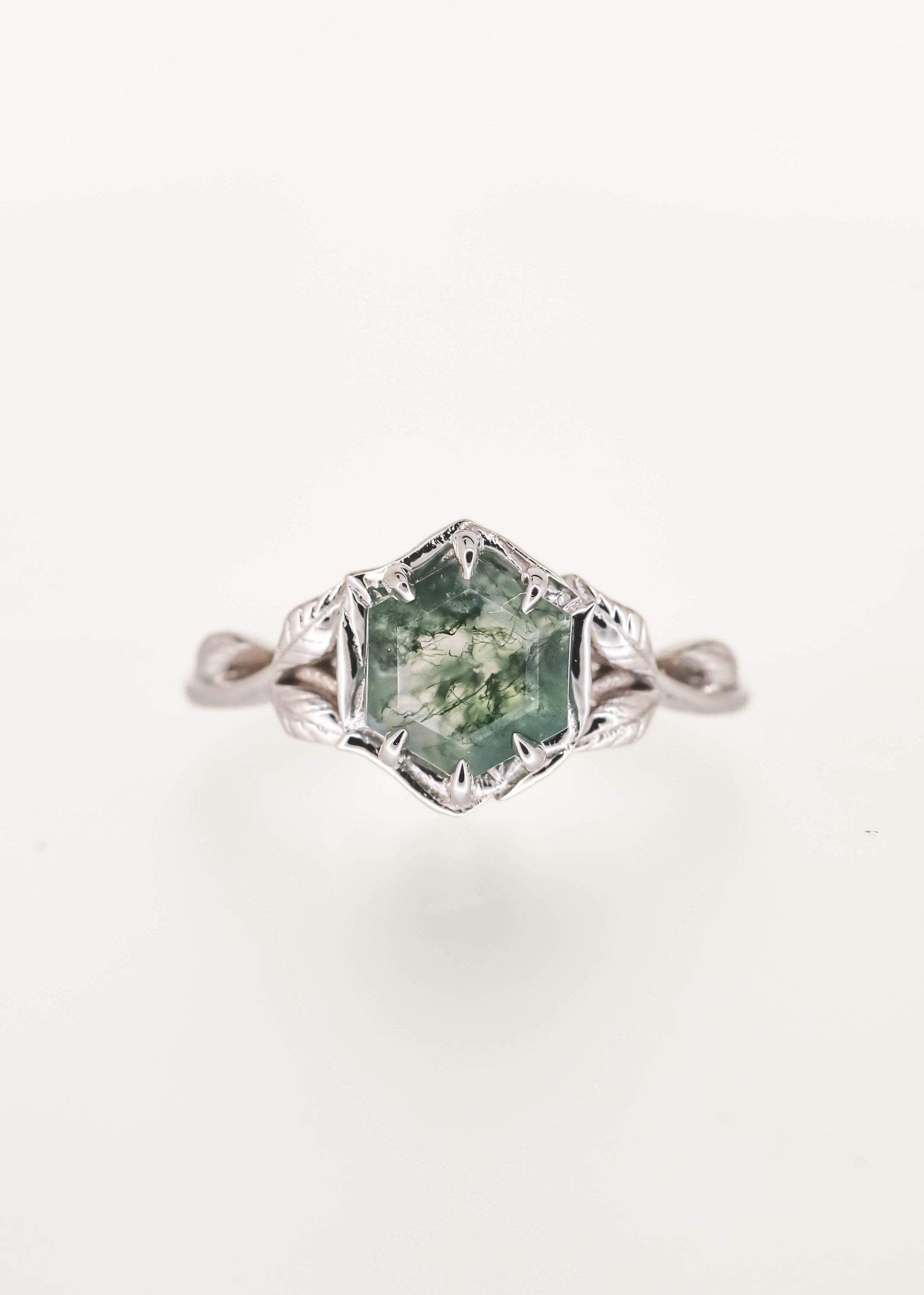 Nature inspired hexagon cut moss agate engagement ring in 14K white gold with a six prong basket and sculpted leaf and vine band