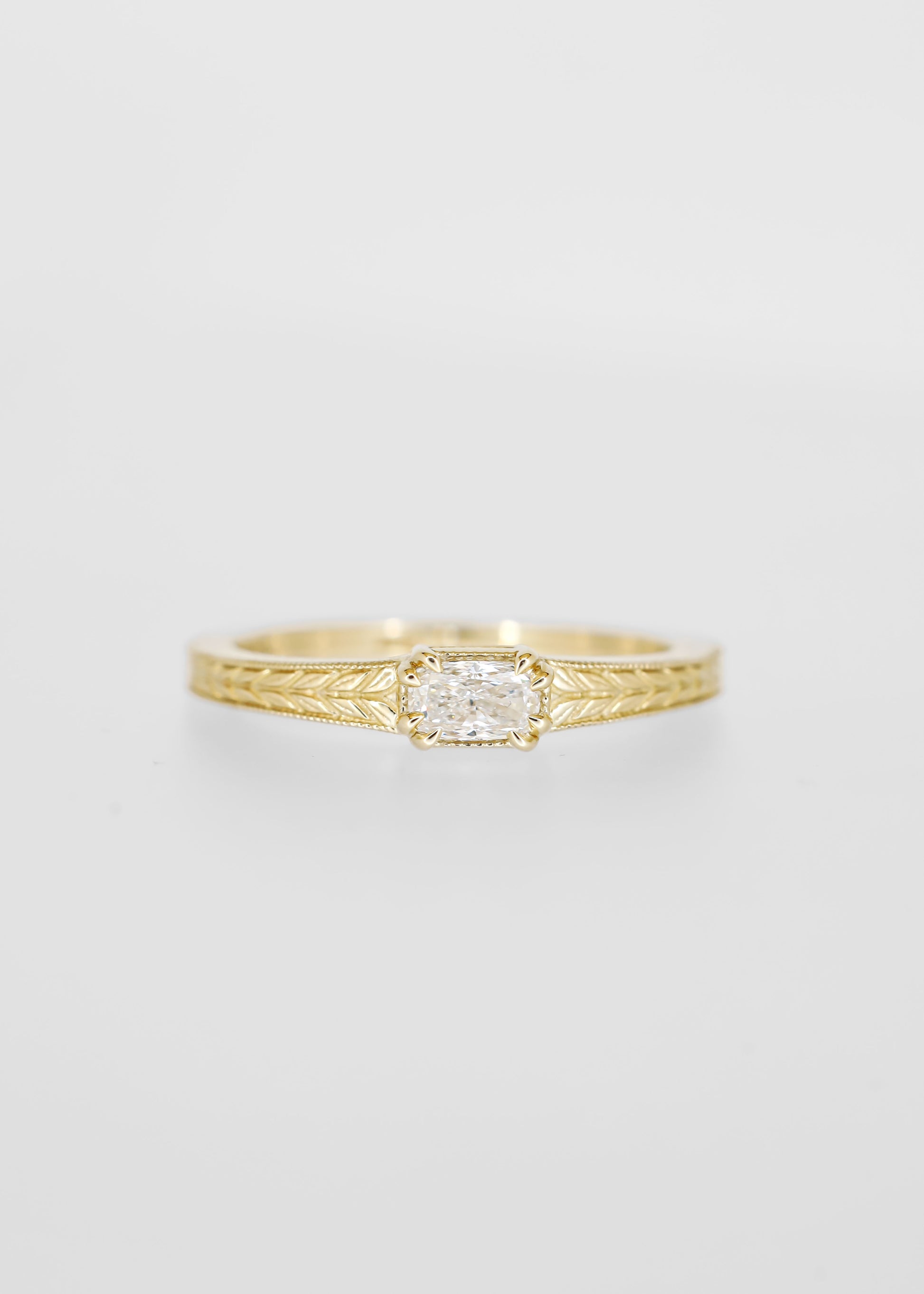 East west cushion cut lab grown diamond engagement ring in 14K yellow gold with milgrain and an engraved wheat band