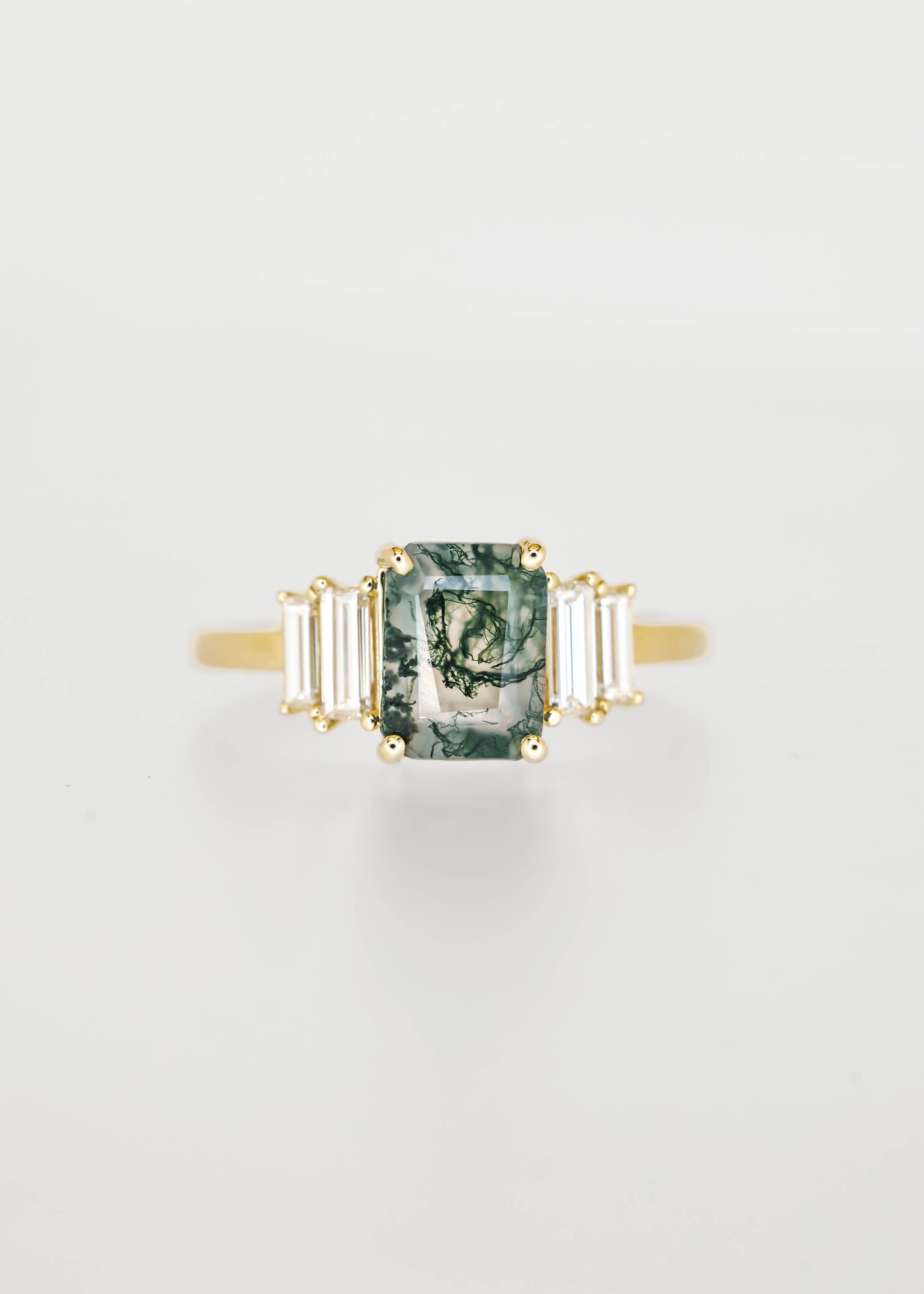 Emerald cut moss agate engagement ring in 14K yellow gold with graduated baguette diamond accent stones