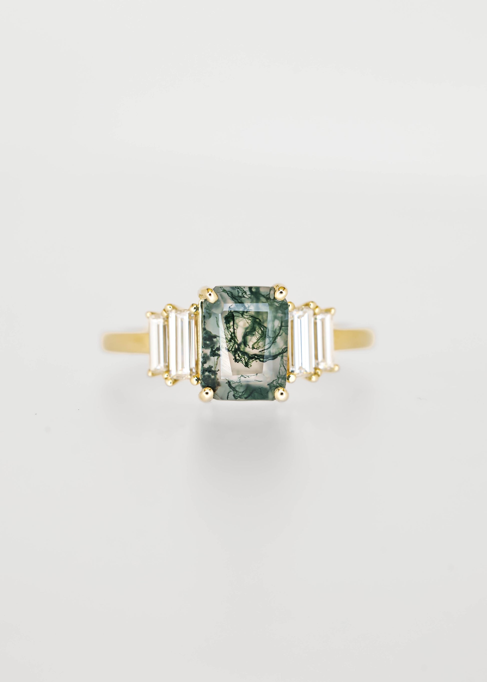 Emerald cut moss agate engagement ring in 14K yellow gold with graduated baguette diamond accent stones
