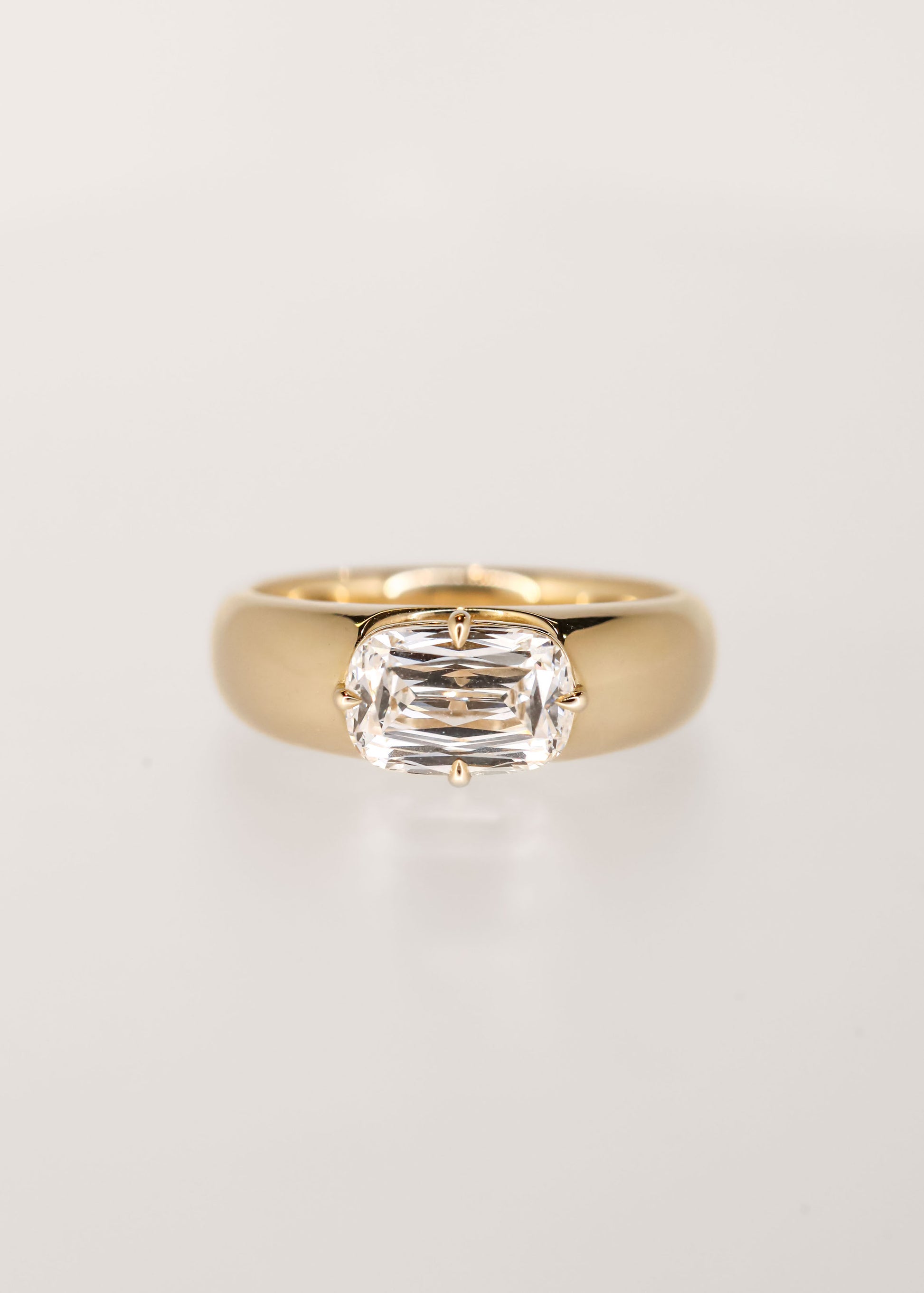 Gender neutral east west ashoka cut lab grown diamond engagement ring in 14K yellow gold with a chunky domed band and compass prongs