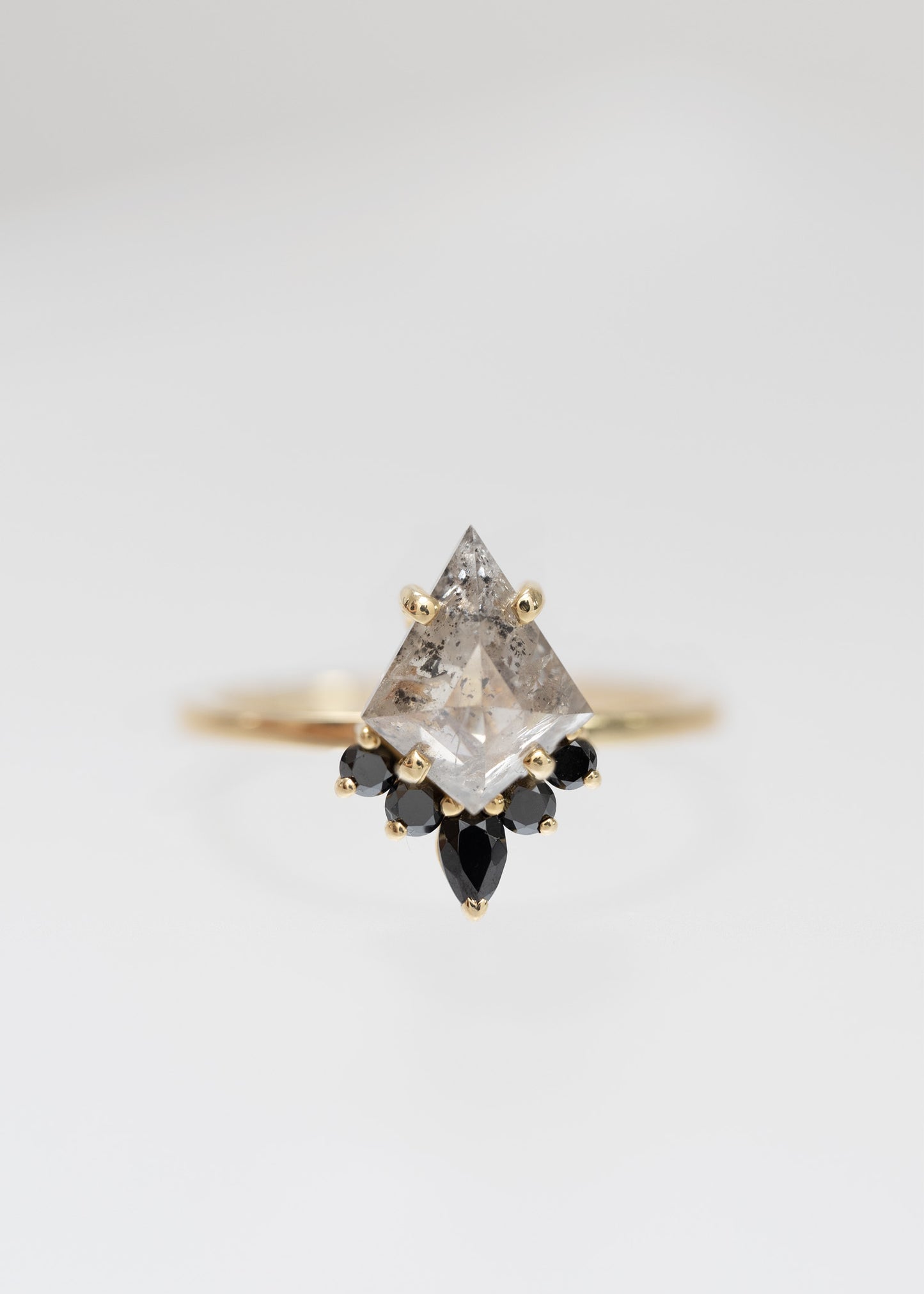 Kite cut salt and pepper diamond engagement ring in 14K yellow gold with a black diamond accent half-halo and pear accent