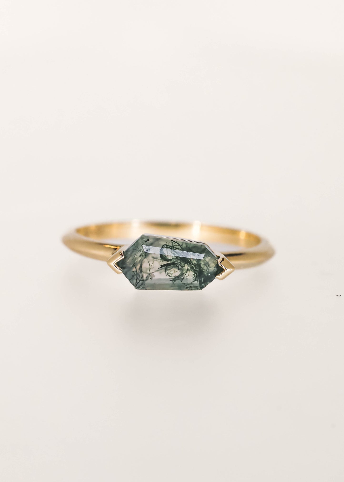 Minimal east west shield cut moss agate engagement ring in 14K yellow gold with half bezel setting
