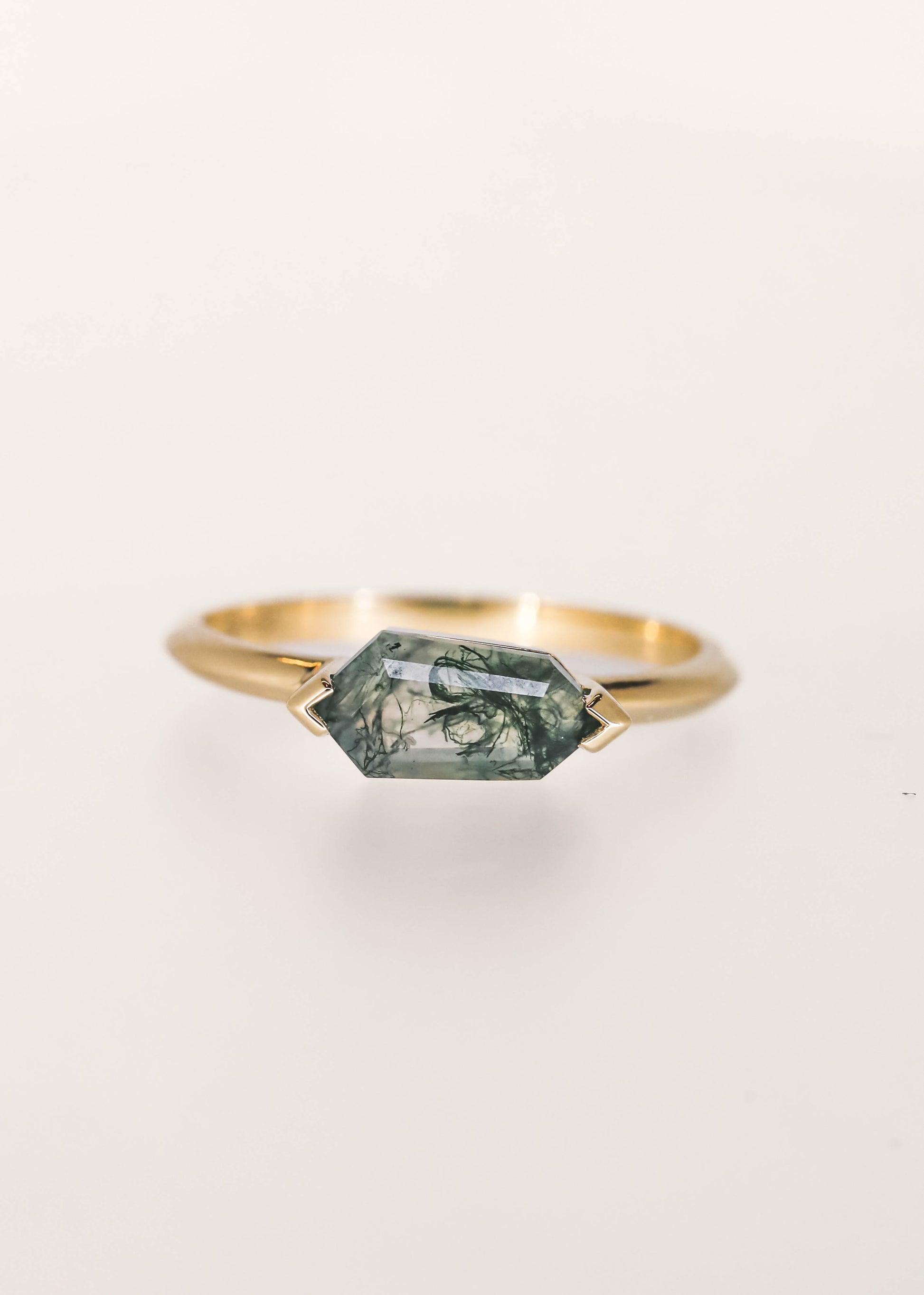 Minimal east west shield cut moss agate engagement ring in 14K yellow gold with half bezel setting