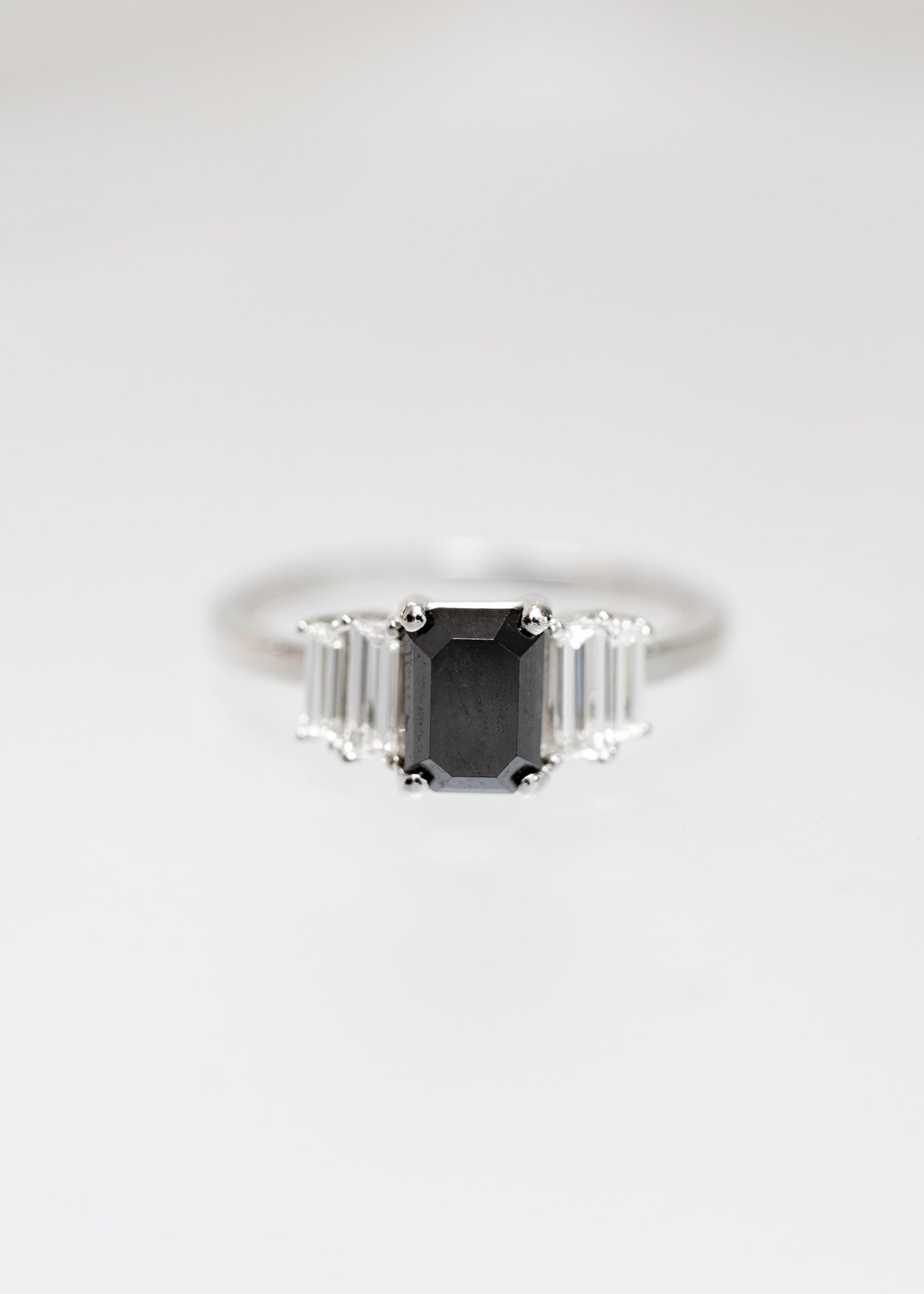 Art Deco emerald cut black diamond engagement ring in 14K white gold with graduated baguette side stones
