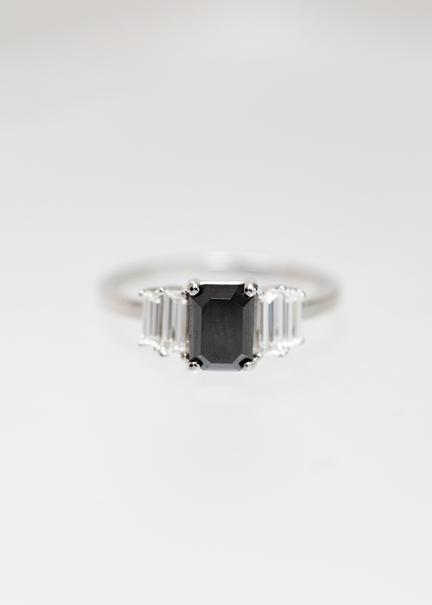 Art Deco emerald cut black diamond engagement ring in 14K white gold with graduated baguette side stones