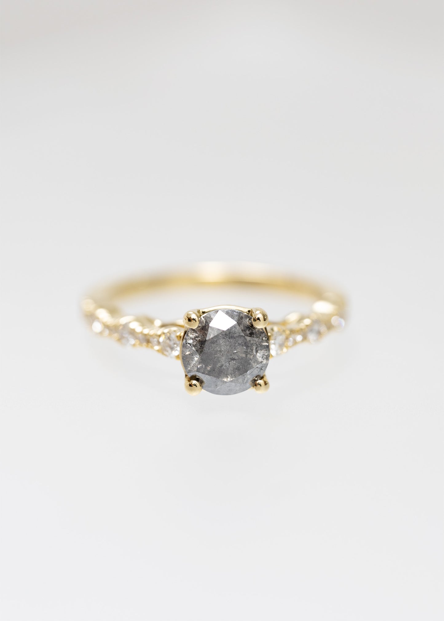 Round salt and pepper diamond engagement ring in 14K yellow gold with a scattered round and marquise diamond accented band