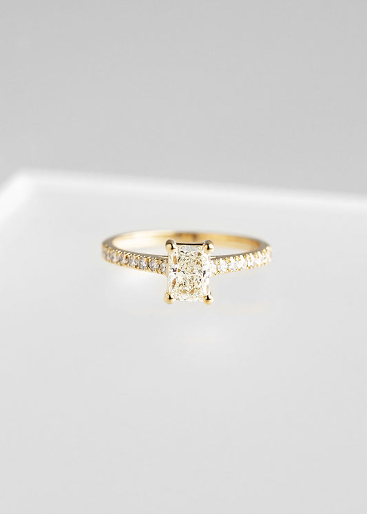 Radiant cut natural diamond solitaire engagement ring in 14K yellow gold with a pavé band