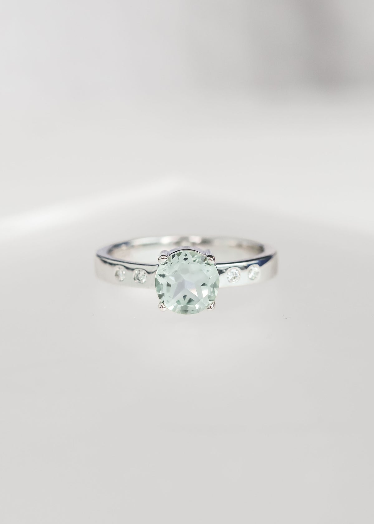 Round green amethyst engagement ring with a five point star cut in 14K white gold with flush set diamond accents