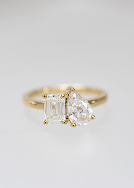 Toi et moi two stone engagement ring in 14K yellow gold with an emerald cut and pear lab grown diamond set side by side