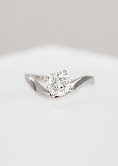 Asymmetrical round natural diamond solitaire engagement ring in 14K white gold with a modern curved band