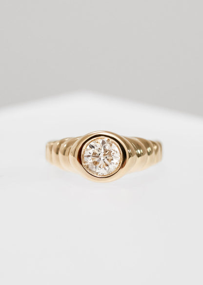 Gender neutral round natural diamond signet engagement ring in 14K yellow gold with a unique ribbed band and full bezel